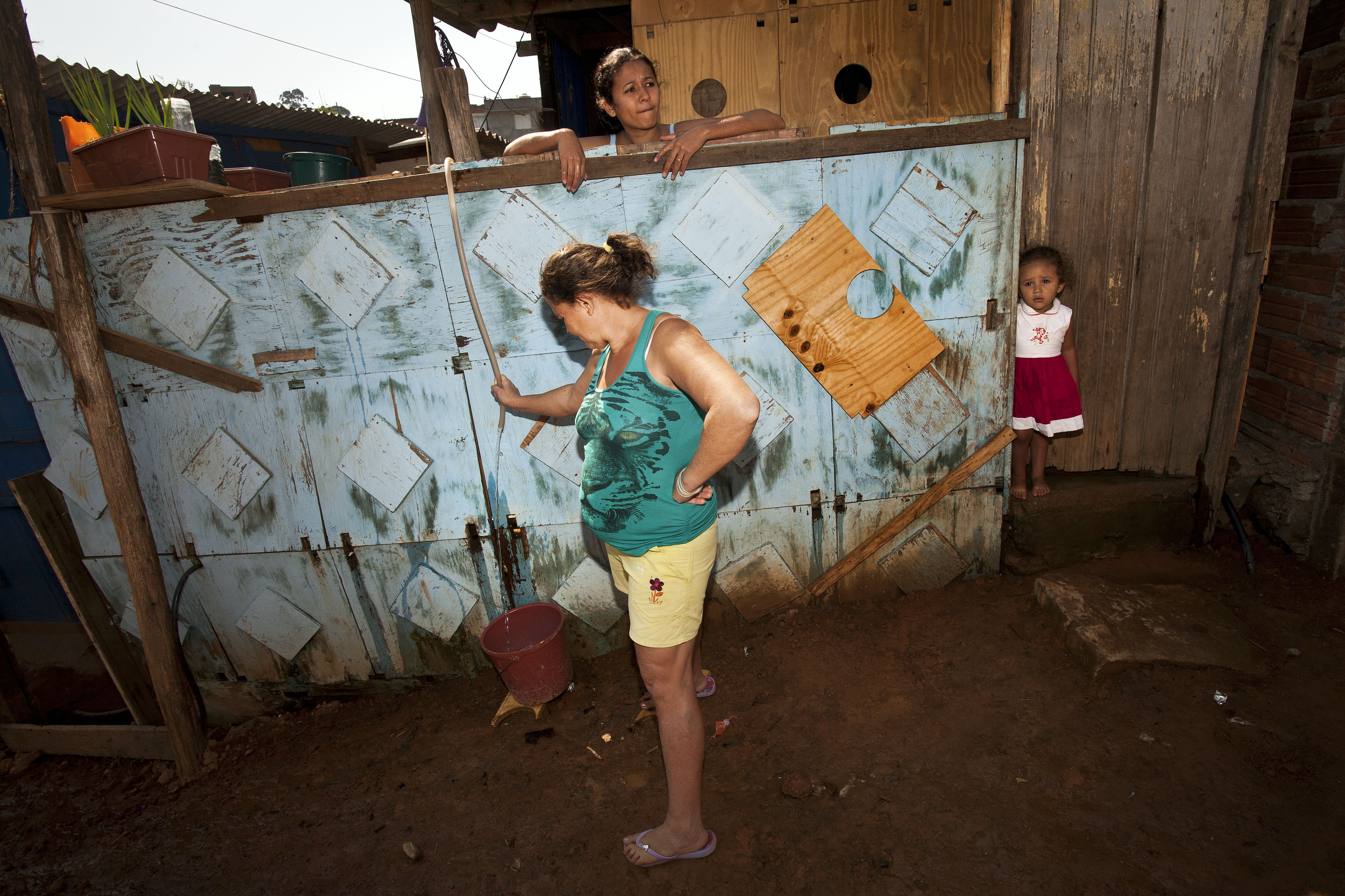Sem água encanada, moradores da Fazendinha se viram com baldes e mangueiras (Foto: Danilo Ramos/RBA)