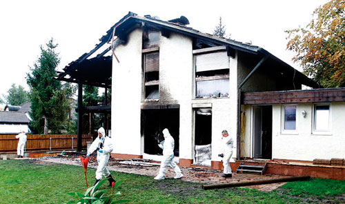 Peritos examinam a casa alugada por Breno, incendiada em setembro de 2011 (Foto:Michaela Rehl/Reuters)