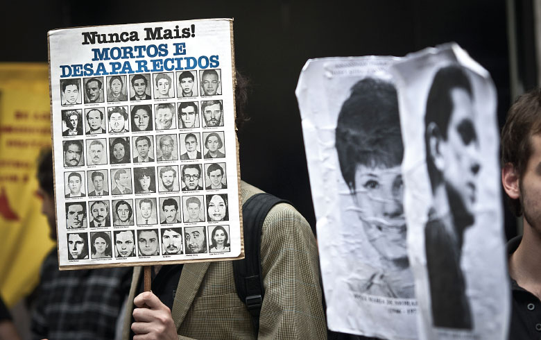 Manifestante carrega cartaz com fotos de vítimas da ditadura